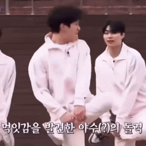 a group of young men are holding hands and one of them is wearing a white hoodie .