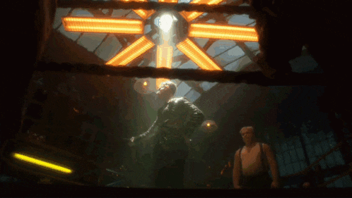 a man is standing in a dark room with a light shining through a window