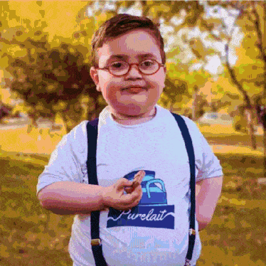 a young boy wearing glasses and suspenders has a t-shirt that says pure lait on it