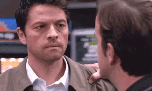 a man in a trench coat is standing next to another man in a store .