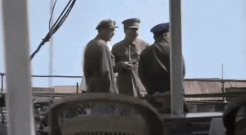 a group of men in military uniforms are standing on a balcony .