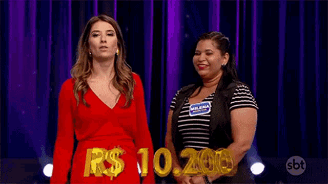 two women are standing next to each other on a stage with a sign that says r $ 10.20 .