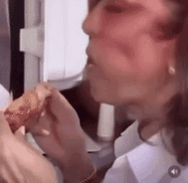 a close up of a woman eating a sandwich .