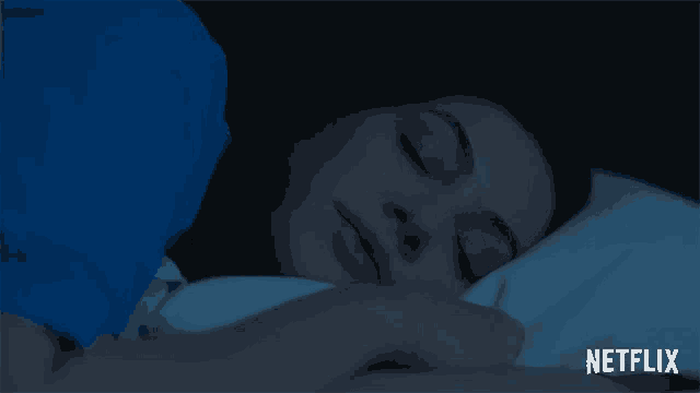 a woman is sleeping in a bed with netflix written on the bottom
