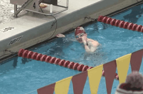 a person is swimming in a pool with a 10 ft sign