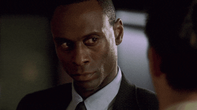 a man in a suit and tie talks to another man with the words god damn right