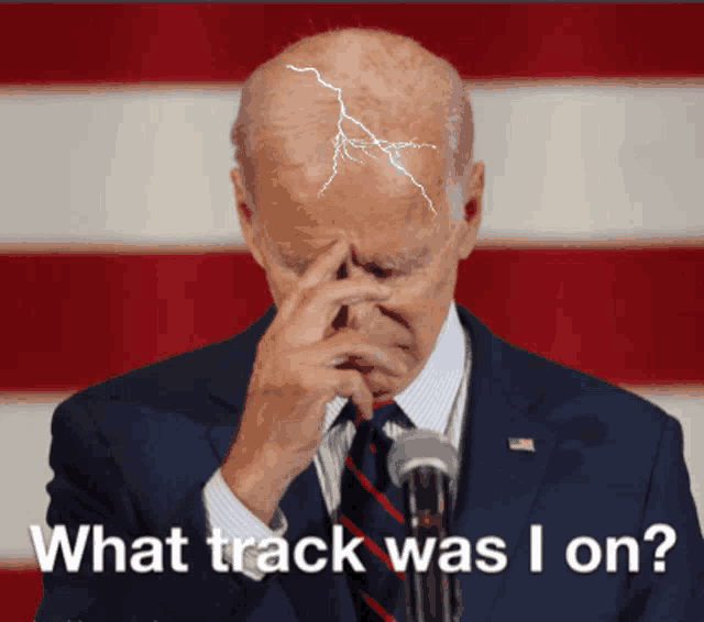 a man in a suit and tie covering his face with his hand and the words " what track was i on " on the bottom