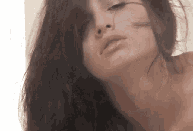 a close up of a woman 's face with long dark hair