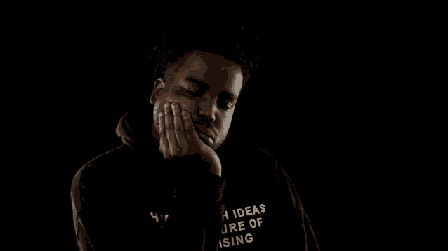 a man wearing a black hoodie that says ideas ure of rising on it