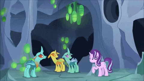 a group of ponies are standing in a cave talking