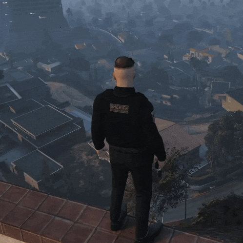 a man in a sheriff 's uniform stands on top of a building