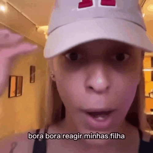 a woman wearing a hat says bora bora reagir minhas filha in a video .