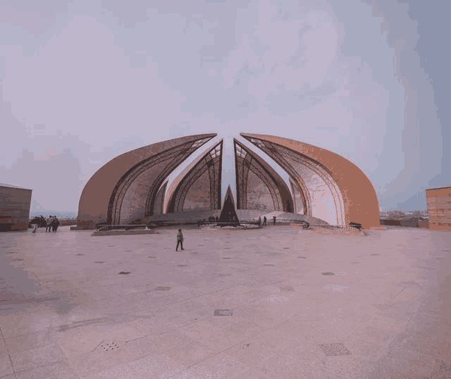 a man stands in front of a large building that looks like a pyramid