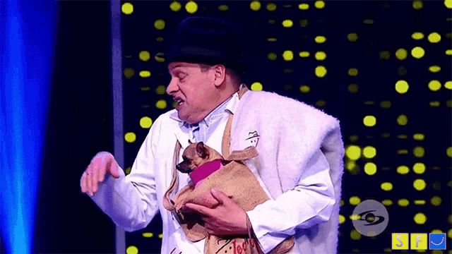 a man is holding a small dog in a bag that says ' coca cola '
