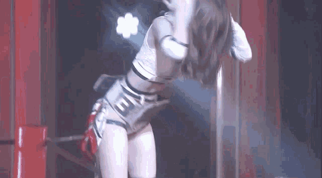 a woman is dancing on a stage in a dark room with chinese writing on the wall .