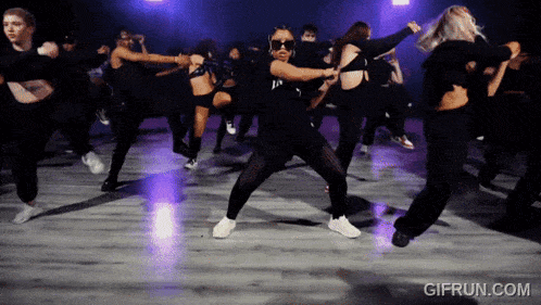 a group of women are dancing on a dance floor with gifrun.com at the bottom of the screen