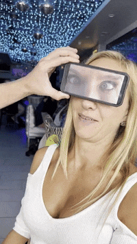 a woman taking a picture of herself with a cell phone