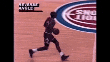 a man is dribbling a basketball on a basketball court with the words reverse angle on the bottom right corner .