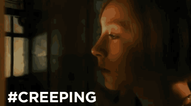 a woman is looking out a window with the hashtag #creeping
