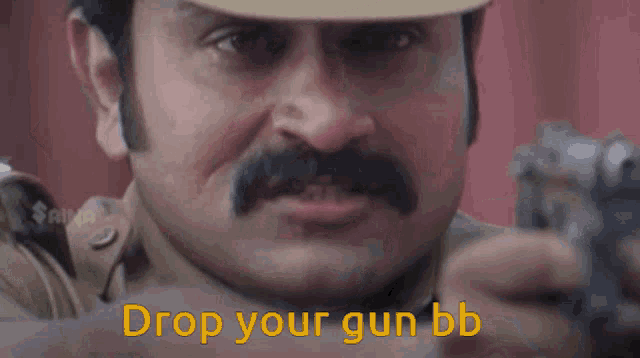a man with a mustache is holding a gun with the words drop your gun bb above him