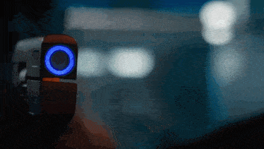 a person is holding a device that has a blue light on it