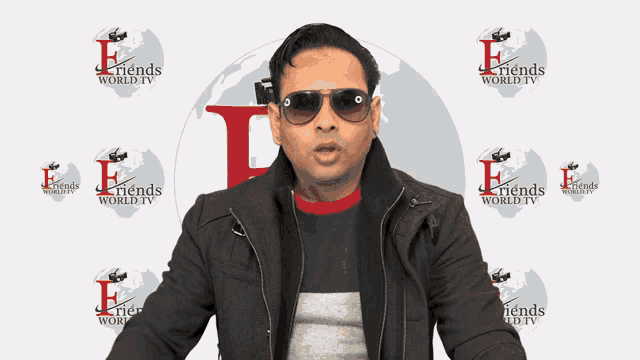 a man wearing sunglasses stands in front of a friends world tv logo