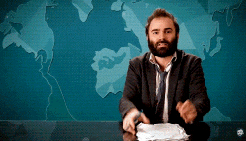 a man with a beard is sitting at a desk in front of a map
