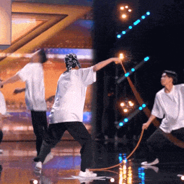 a group of men are dancing on a stage and one of them is holding a rope