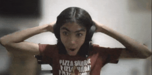 a girl wearing headphones and a red shirt that says pizza shark on it