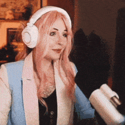 a woman wearing headphones and a pink wig is holding a microphone
