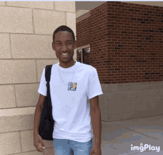 a young man wearing a white t-shirt with a picture of a man on it