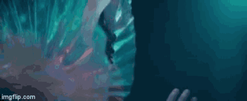 a close up of a person 's face in a dark room with a blue background .