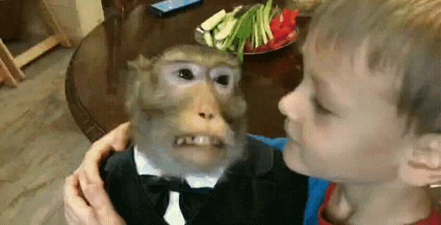 a young boy is holding a monkey in a tuxedo
