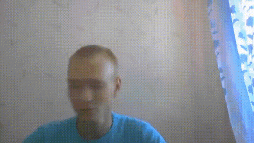 a man in a blue shirt is looking at the camera