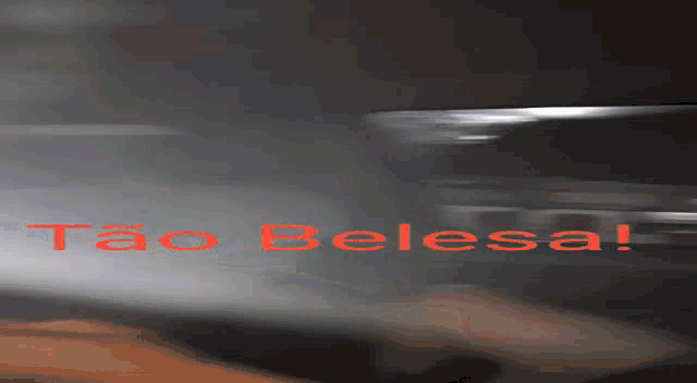 a person is standing in a dark room with the words " tao belesal " written in red