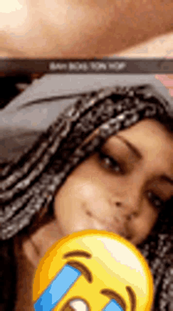 a woman with braids is taking a selfie with a smiley face .