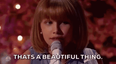 a little girl is singing into a microphone and saying `` thats a beautiful thing . ''