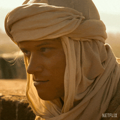 a close up of a man wearing a scarf with netflix written on the bottom right