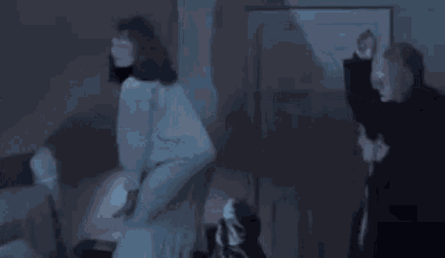 a man and a woman are standing in a dark room .