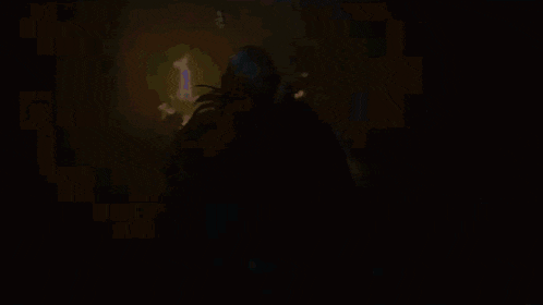 a silhouette of a man standing next to a woman in a crib with christmas lights on it