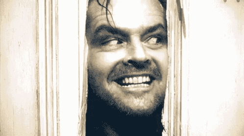 a man with a beard is smiling through a doorway