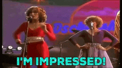 two women singing into microphones with the words " i 'm impressed " behind them