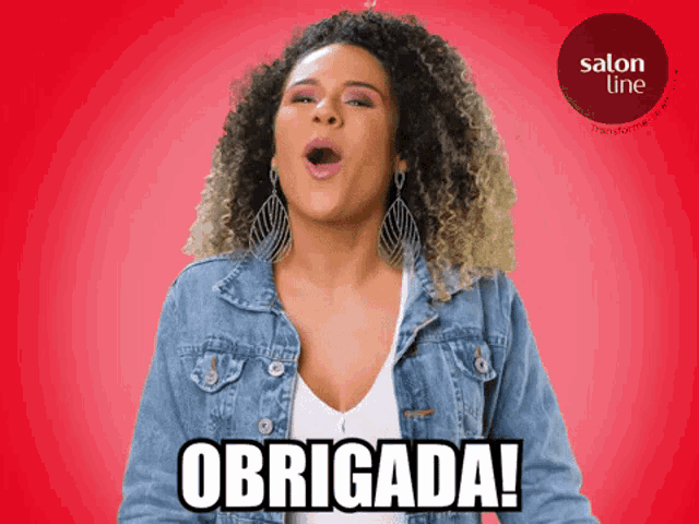 a woman wearing a denim jacket and earrings says obrigada