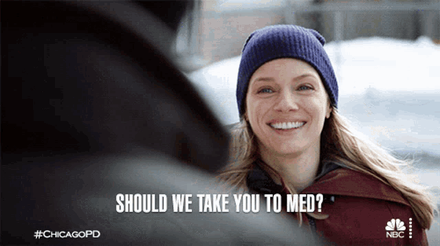 a woman wearing a blue beanie is smiling and says should we take you to med