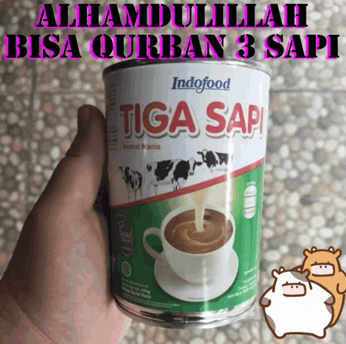 a can of indofood tiga sapi is being held in someone 's hand