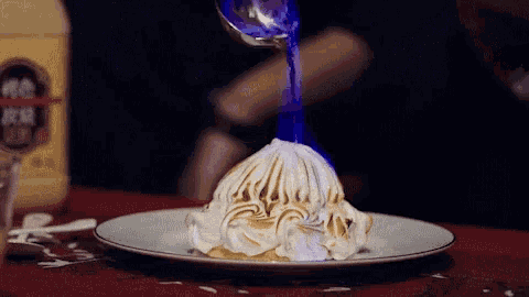 a bottle of alcohol is behind a plate of food