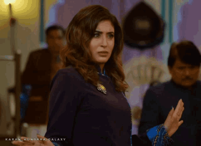 a woman in a purple top with the word karan kundra galaxy on the bottom right