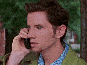 a man in a green jacket is talking on his cell phone