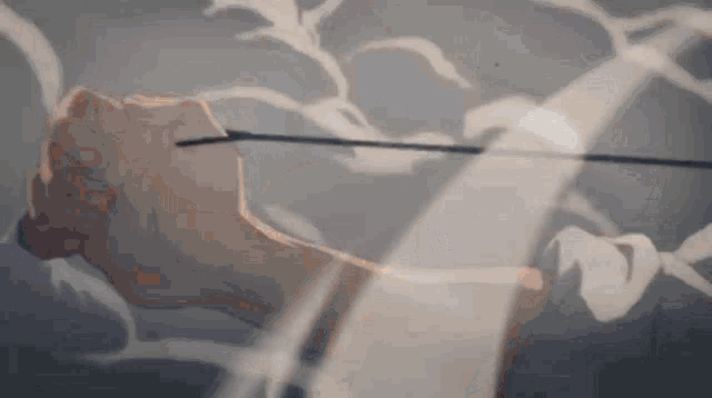 a close up of a person 's fist holding a sword with smoke coming out of it .