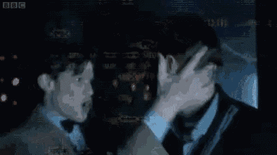 two men are kissing each other in front of a screen .